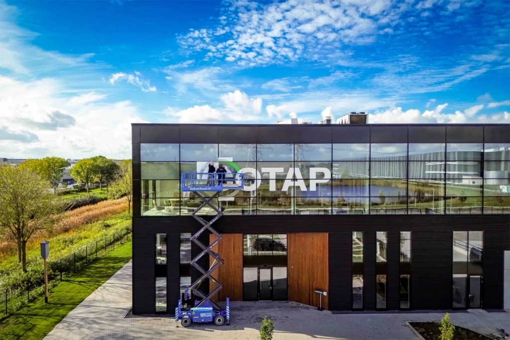Montage van gevelbelettering door het montageteam van Prestige Reclame op een hoogwerker bij het bedrijfspand van Cotap.
